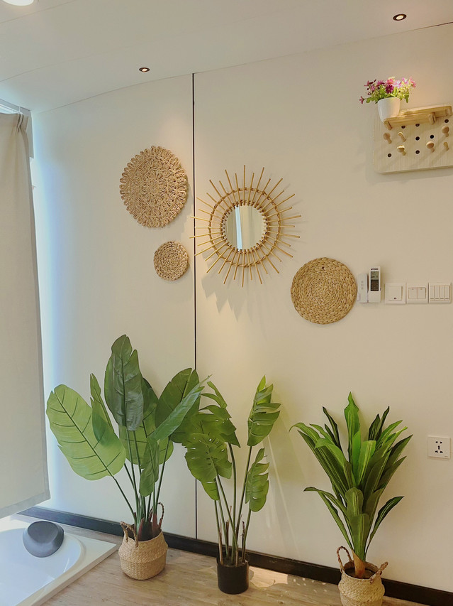 An elegant bedroom at Sunny Holiday near Pulau Bum Bum featuring modern style woven wall decor, tropical plants, polished timber floors, a sunken bathtub, and air con.