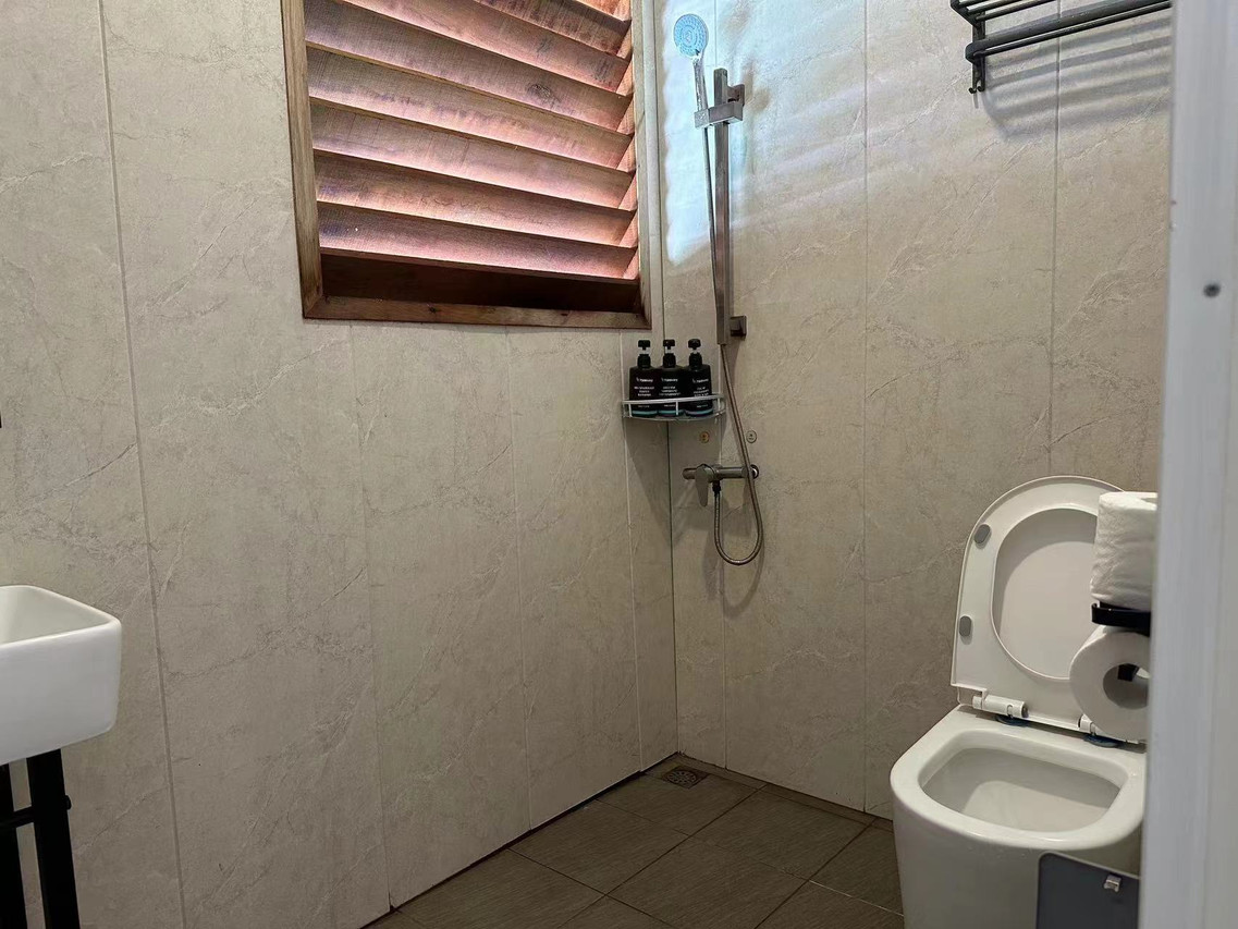 A simple and clean bathroom at Sunny Holiday, a floating resort in the Semporna Islands area.